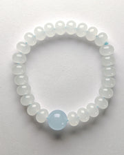 Beaded bracelet with a central light blue bead on a white background